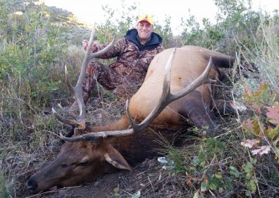 Hunter with his Elk in a meadow