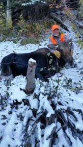 Hunter in the snow with a moose