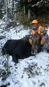 Hunter with his moose in the snow