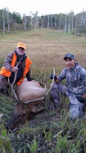 Guide and Hunter with their Elk in Meadow