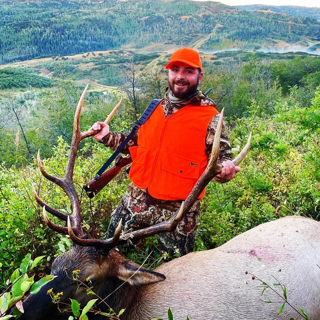 Hunter with Elk with views of surrounding mountains